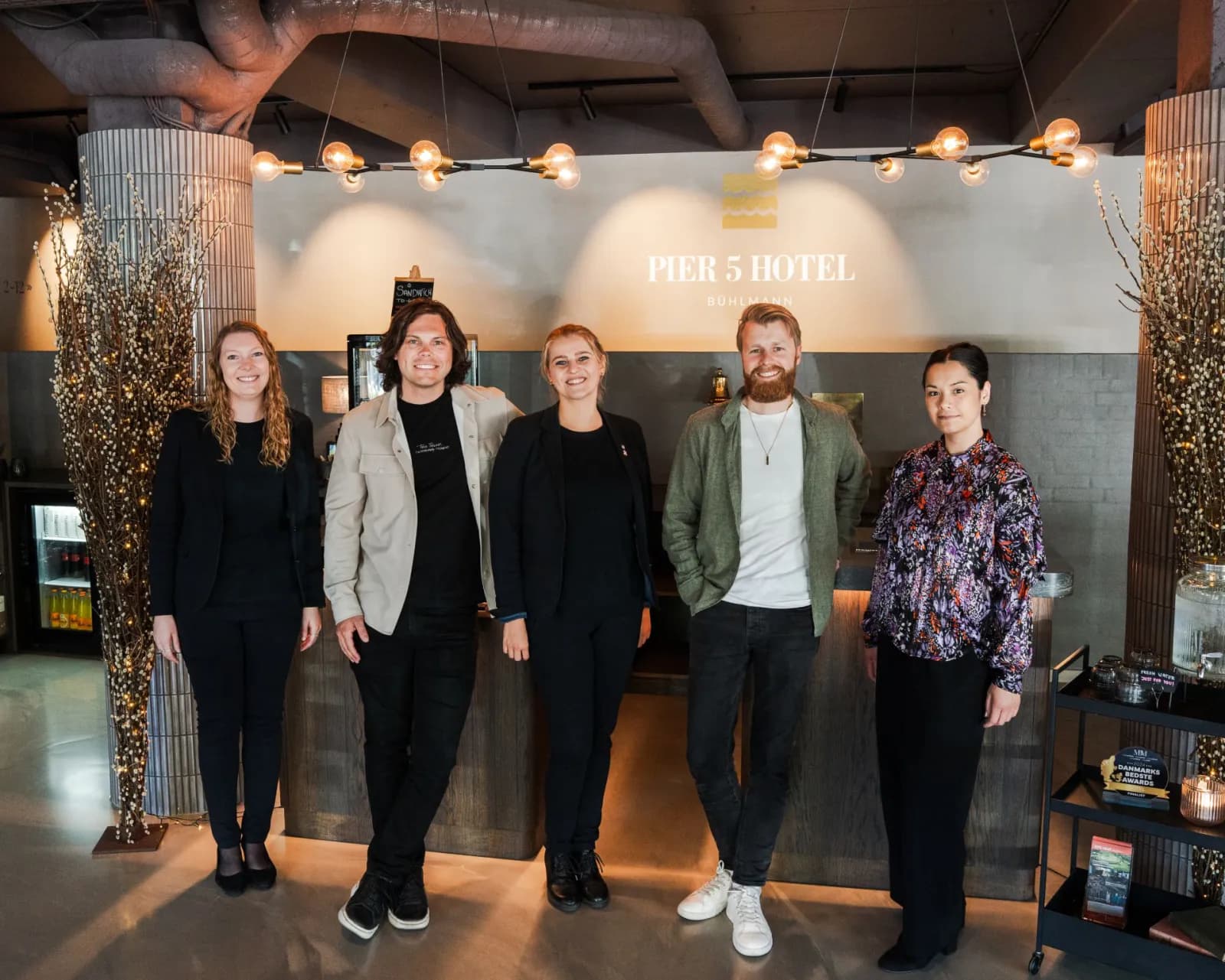 Altek founders Kristoffer and Jon-Fredrik standing with the front-desk team at Pier 5 Hotel.